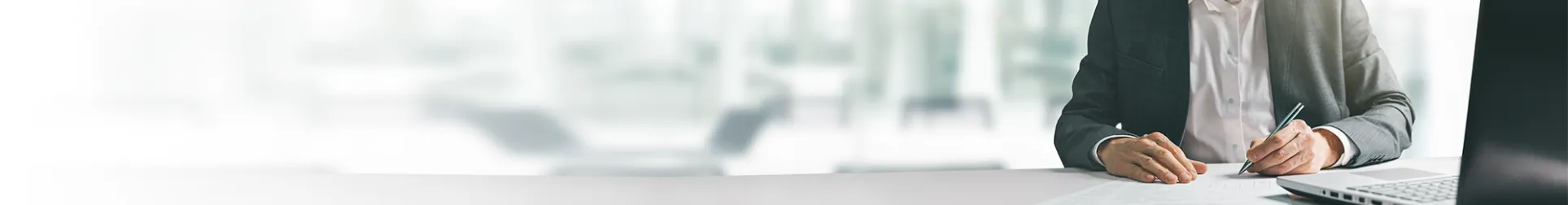 persona en un escritorio escribiendo o tomando notas en un entorno corporativo