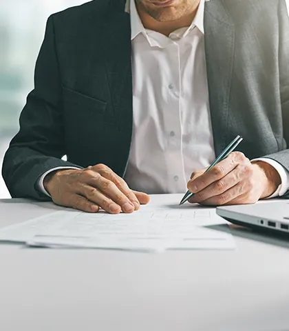 persona en un escritorio escribiendo o tomando notas en un entorno corporativo